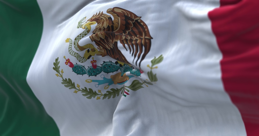 Close-up view of the mexican national flag waving in the wind. Mexico is a country in the southern portion of North America. Fabric textured background. Selective focus. Seamless loop in slow motion Royalty-Free Stock Footage #1092923973