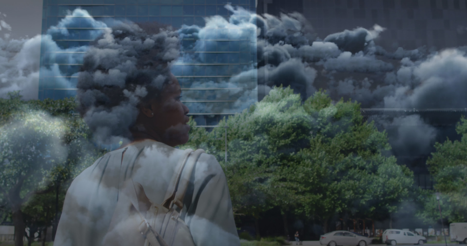 Animation of clouds over african american businesswoman walking. Global business and digital interface concept digitally generated video.