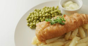 Video of fish, chips and peas on plate with dip. tasty hot homemade fast food meal.