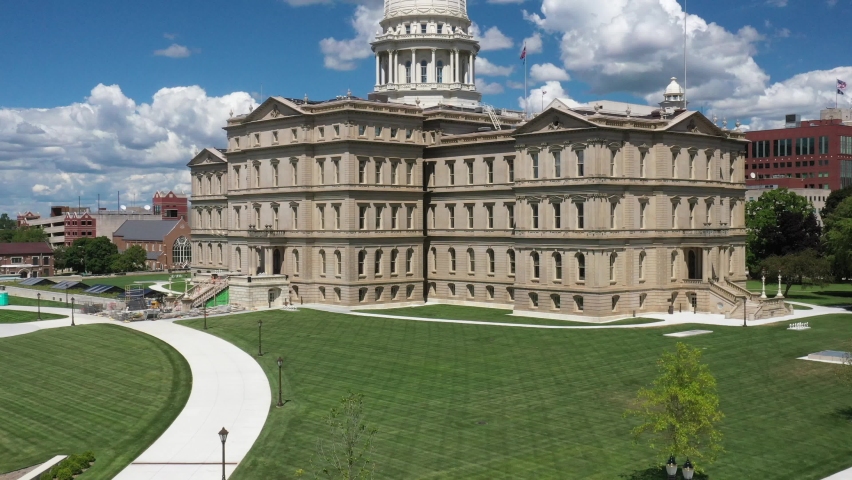 Michigan state capitol building in Lansing, Michigan close up with clouds and drone video moving up.