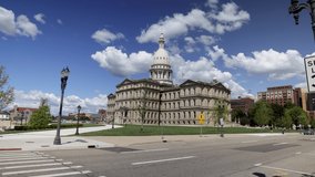 Michigan state capitol building in Lansing, Michigan with ground level time lapse video showing fast moving clouds.
