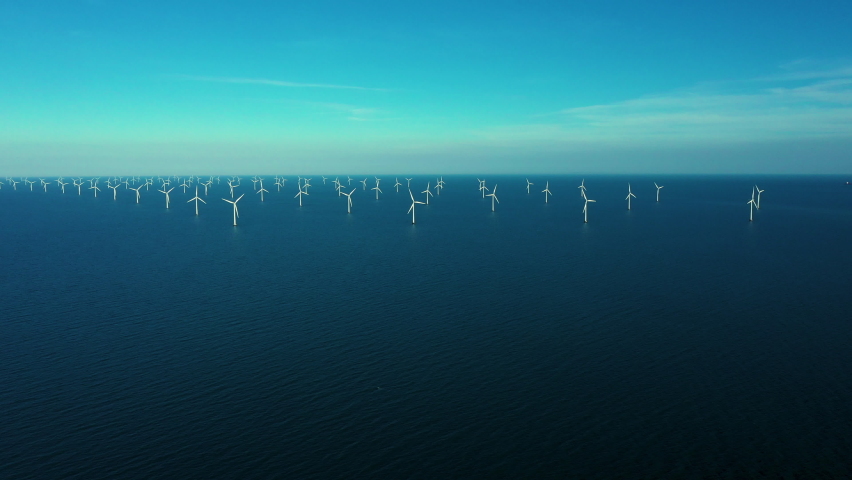 Aerial drone shot of oceanic wind turbines at the Rødsand wind farm in Denmark. Green energy is a promising alternative to fossil fuels and the need for a transition is urgent.  | Shutterstock HD Video #1092938309
