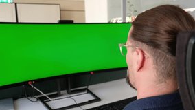 Male businessman having a online video meeting conference during quarantine. Zoom meeting in the office. Businessman speaks, using green screen. TV Wall. Industrial engineer having important meeting