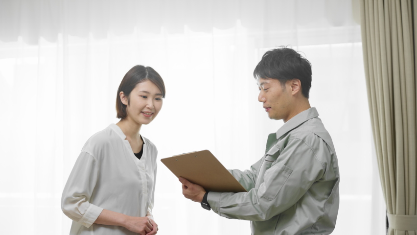 Man in work clothes explaining to homeowner Image of safety inspection
