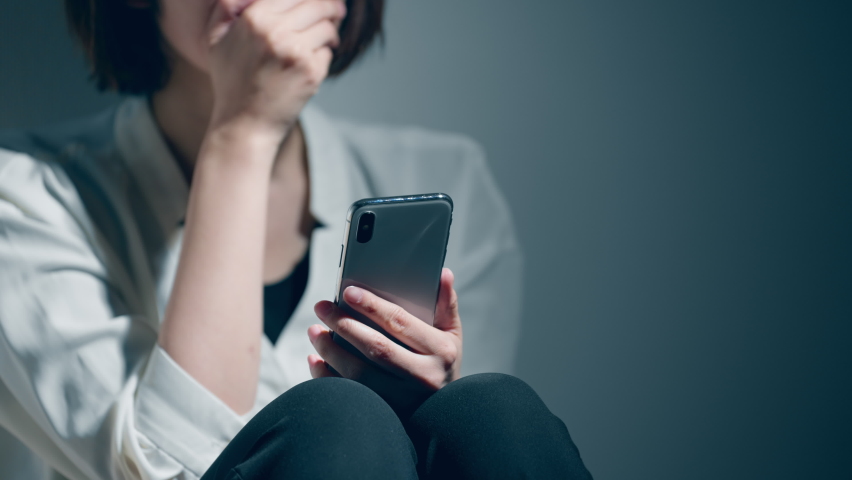 A young woman with a mental disorder uses a smartphone.