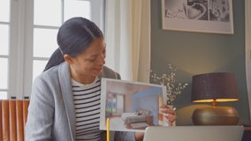 Female architect or interior designer working from home having meeting via video call to show work - shot in slow motion - Powered by Shutterstock - Get 15% off with code: PIKWIZARD15