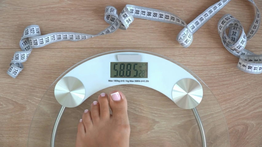 Girl On Scale Measure Weight. Fit Female Step on Bathroom Scale. Fitness Diet Woman Feet Standing Weighing Scales. Close Up Woman Checking BMI Weight Loss. Royalty-Free Stock Footage #1092942311