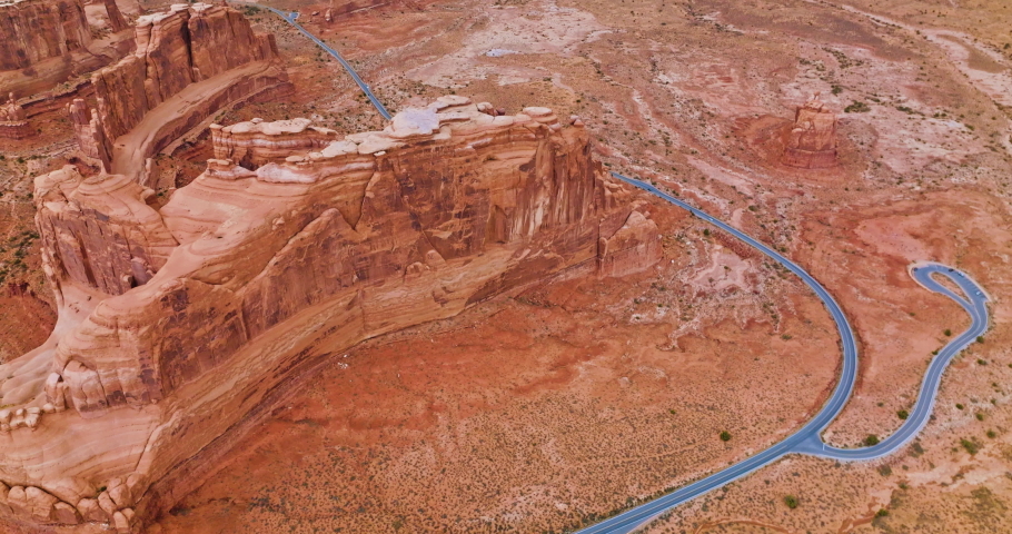 Outstanding high orange rocks of Bryce canyon in Utah, USA. Flying over the rounded tops of rocks and highway with cars passing by. Aerial view.