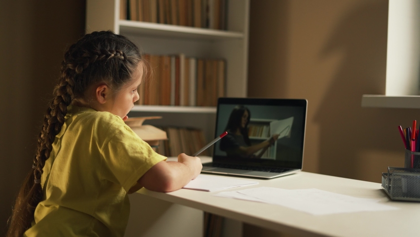 Girl of the student studies at home remotely. The student is engaged with the help of a service on a computer. The girl uses a computer and its services to study at home. Online school new normal | Shutterstock HD Video #1092956223