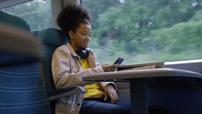 Attractive young teen on a video call during a journey on a train, in slow motion