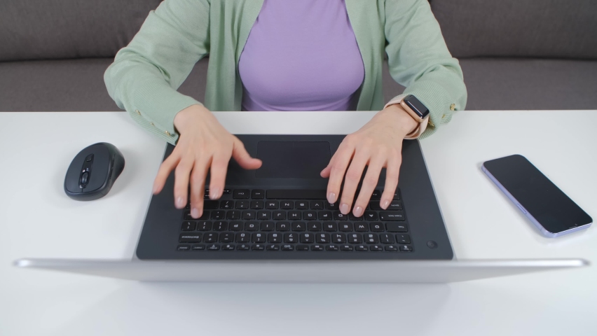 Female person typing text on notebook keyboard. Overhead stock video of freelancer working on laptop computer at home | Shutterstock HD Video #1092962473