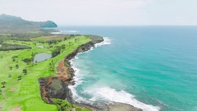 Golf course aerial 4k view stock video footage. Bright glade with green grass and Pacific ocean landscape. Beautiful green planet earth top view. Cinematic shot of golf club on Kauai island Hawaii