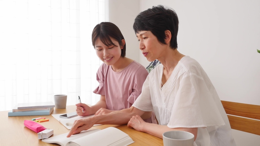 Asian woman studying with her mother at home