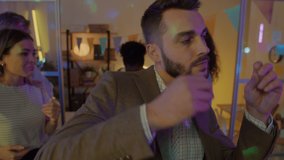 Slow motion portrait of drunk businessman dancing with colleagues in decorated office in the evening. Leisure activity and corporate event concept. - Powered by Shutterstock - Get 15% off with code: PIKWIZARD15