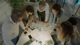 Motivated businesspeople talking looking at documents discussing ideas brainstorming in office at night. Cooperation and entrepreneurs concept. - Powered by Shutterstock - Get 15% off with code: PIKWIZARD15