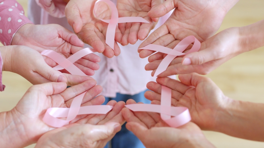 Group of woman’s hand holding pink ribbon for October breast cancer awareness month | Shutterstock HD Video #1092971909