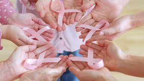 Group of woman’s hand holding pink ribbon for October breast cancer awareness month - Powered by Shutterstock - Get 15% off with code: PIKWIZARD15
