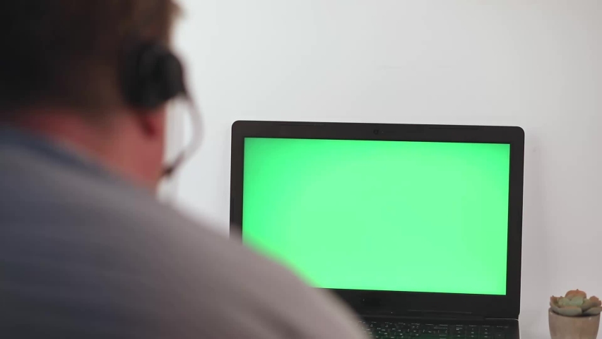 Man using notebook with green screen. Empty chroma key laptop for watching. Technology concept video template. | Shutterstock HD Video #1092974379