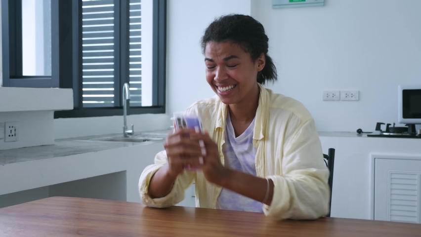 Excited youg woman clenching fists and rejoicing while receiving great news on her smartphone. Online business, student, freelance work, university enrollment, e-learning, goals achievement concept