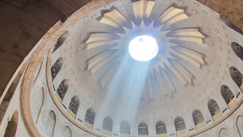 Ray of sun from dome and crowd of people in the Church of the Holy Sepulcher timelapse. Sacred place in the Christian Quarter of the Old City of Jerusalem where Jesus was crucified and buried.