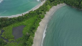 Aerial shot of Whale tail shaped beach in Manuel Antonio National Park, Costa Rica. Sunny weather in south Puntarenas. 4K videos.