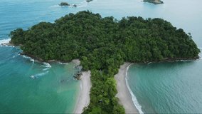 Aerial away shot of Whale tail shaped beach in Manuel Antonio National Park, Costa Rica. rocky point of Punta Uvita. Sunny weather in south Puntarenas. 4K videos.