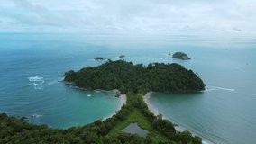 Aerial drone shot of Whale tail shaped beach in Manuel Antonio National Park, Costa Rica. Sunny weather in south Puntarenas. 4K videos.