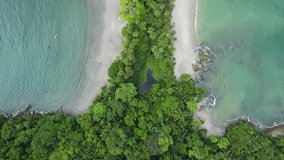 Aerial drone headshot Whale tail shaped beach in Manuel Antonio National Park, Costa Rica. rocky point of Punta Uvita. Sunny weather in south Puntarenas. 4K videos.