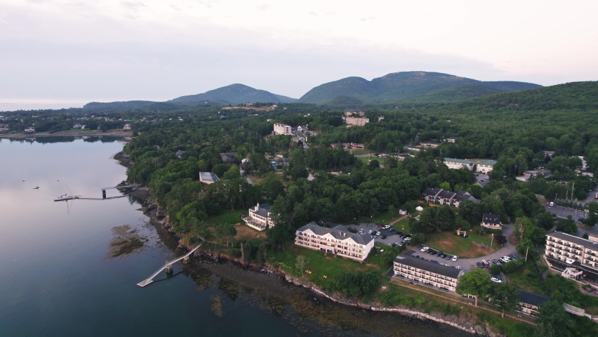 Aerial view of hotels, homes, buildings, and Acadia National Park forest and mountains on Bar Harbor, Maine peninsula 