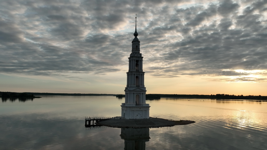 The famous bell tower in Kalyazin on the river Volga. Old steeple sticking out in the middle of the river. Flying around tower at early morning. Aerial shot. | Shutterstock HD Video #1092986299