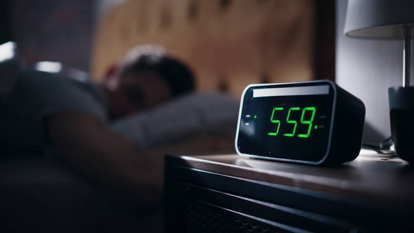 Man Wakes Up, Turns off Alarm Clock with Frustration. Early Rising Productive Man Ready Start a Day full of New Problems. Focus on the Clock Showing Six A.M. Bedside Nightstand Bedrooom Apartment Royalty-Free Stock Footage #1092986365
