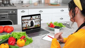 Man chef food blogger in computer screen greets tells recipe dish teaches housewife cooking culinary lesson. Woman in kitchen study online video call webcam laptop listen teacher drinks coffee tea