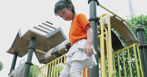 4K video slow motion Asian children wear orange t-shirt play in playground. Concept for funny and active activity of kid.