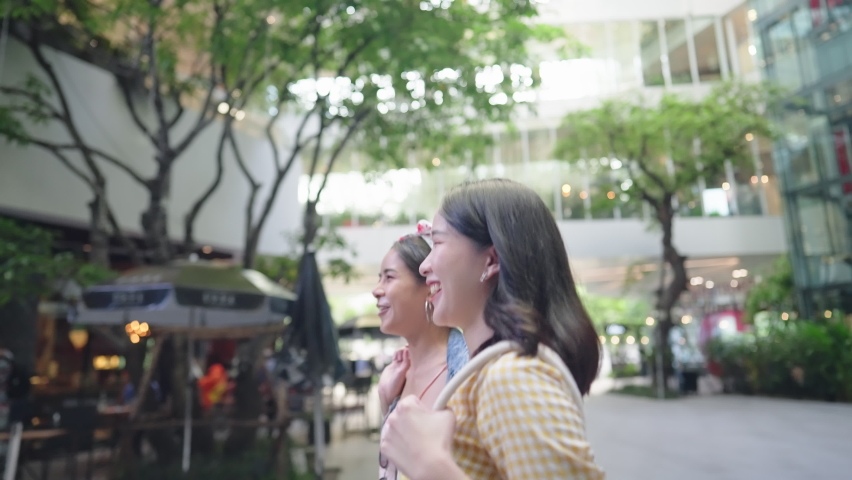 Two young adult asian girlfriend going out shopping at outdoor downtown city shopping district, femininity trust each other, walking along café and restaurants, window shopping, trendy and fashionable Royalty-Free Stock Footage #1093003903