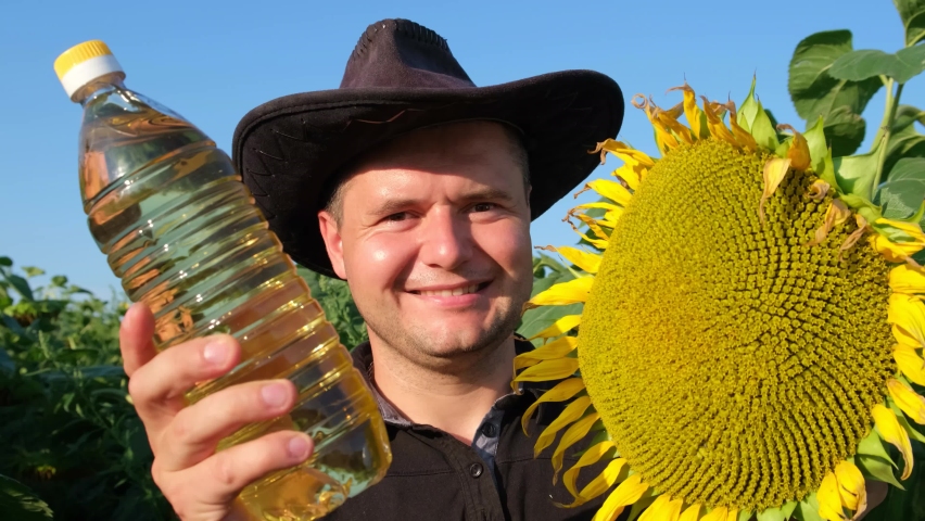 A European farmer demonstrates a sunflower oil product right in the field. Agriculture worker