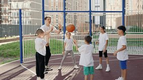 Schoolkids playing with ball on their sport class with male teacher outdoor. Healthy sport and education concept - Powered by Shutterstock - Get 15% off with code: PIKWIZARD15