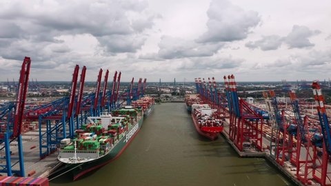 Hamburg, Germany - July 2022: Aerial view on the cranes and loaded cargo ships in Burchardkai Container Terminal (CTB) in the Port of Hamburg (Hamburger Hafen)