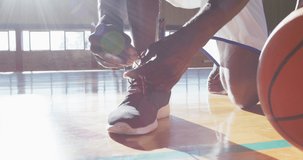Animation of work it over african american basketball player tying shoes. Sport, competition and communication concept digitally generated video.