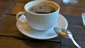 Black coffee in a white ceramic cup. 4k video footage