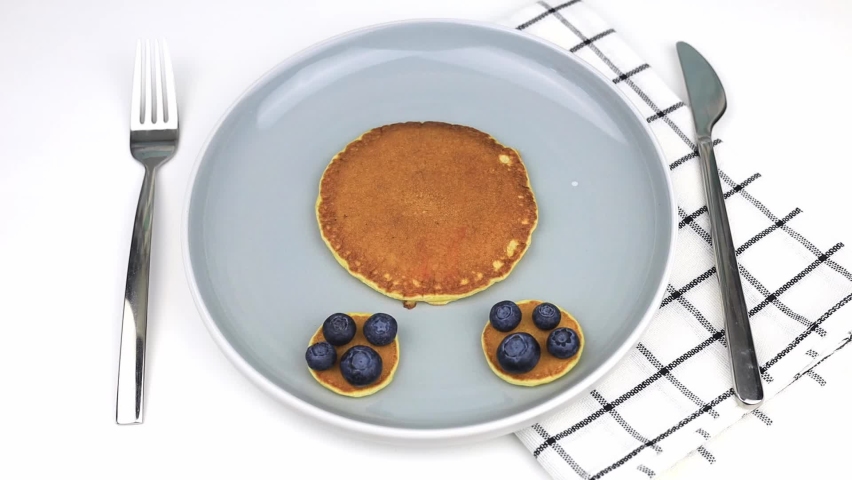 Dog with strawberries, blueberries and bananas made from American pancakes. Food for kids, playful and creative. View from above. Royalty-Free Stock Footage #1093029925