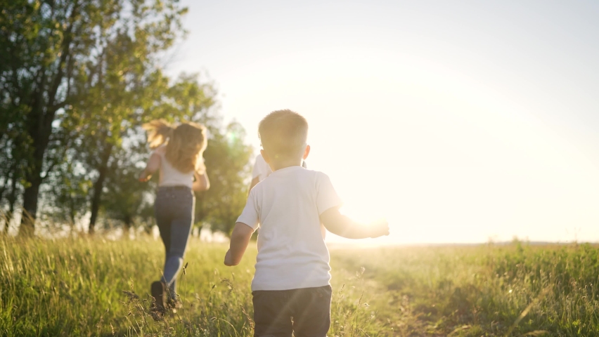 Happy family of children in summer outdoors.Children run together on grass in meadow.Silhouette of group of people playing in field.Boys and girls have fun run in the park at sunset.The Joy of Friends | Shutterstock HD Video #1093042445