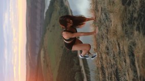 beautiful woman with athletic body doing plank run outdoors at sunset with beautiful view, woman doing street workout, fitness trainer. Vertical video