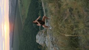 beautiful woman with athletic body doing squats and lunges outdoors at sunset, sport and healthy lifestyle concept. Vertical video