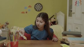 Bored schoolgirl playing with her toys at a table in her home. A 10-12 year old child is playing with a small model airplane, she is doing it. Portrait of a student. - Powered by Shutterstock - Get 15% off with code: PIKWIZARD15