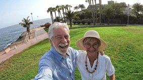 Cute couple of old and mature people having fun together at the park with the beach at the background. Two seniors jumping and looking at the camera taking a selfie together.
 - Powered by Shutterstock - Get 15% off with code: PIKWIZARD15
