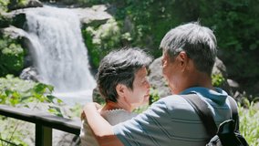 old couple enjoying waterfall landscape together cuddling - Powered by Shutterstock - Get 15% off with code: PIKWIZARD15