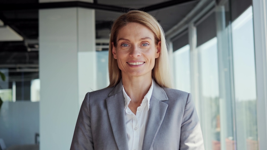 Confident smiling mid aged businesswoman professional financial advisor, executive leader, manager, female lawyer or woman entrepreneur standing in office posing for headshot business portrait.  Royalty-Free Stock Footage #1093057885