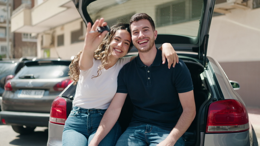 Young hispanic couple hugging each other holding key of new car at street Royalty-Free Stock Footage #1093061193