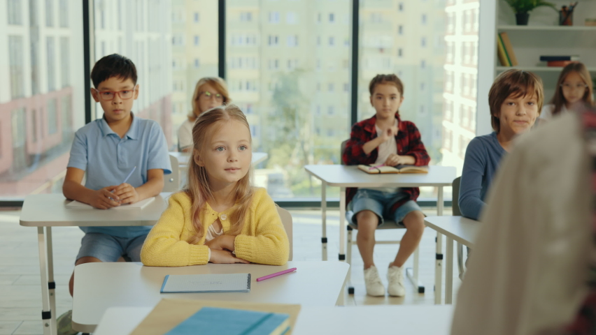 Junior school students raise their hand in class to answer the teacher's question. Children know the answer to the question and raise their hand to answer it. People and educational concept Royalty-Free Stock Footage #1093066223