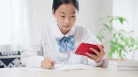 Asian female student studying with a smart phone. Online class. e-learning.